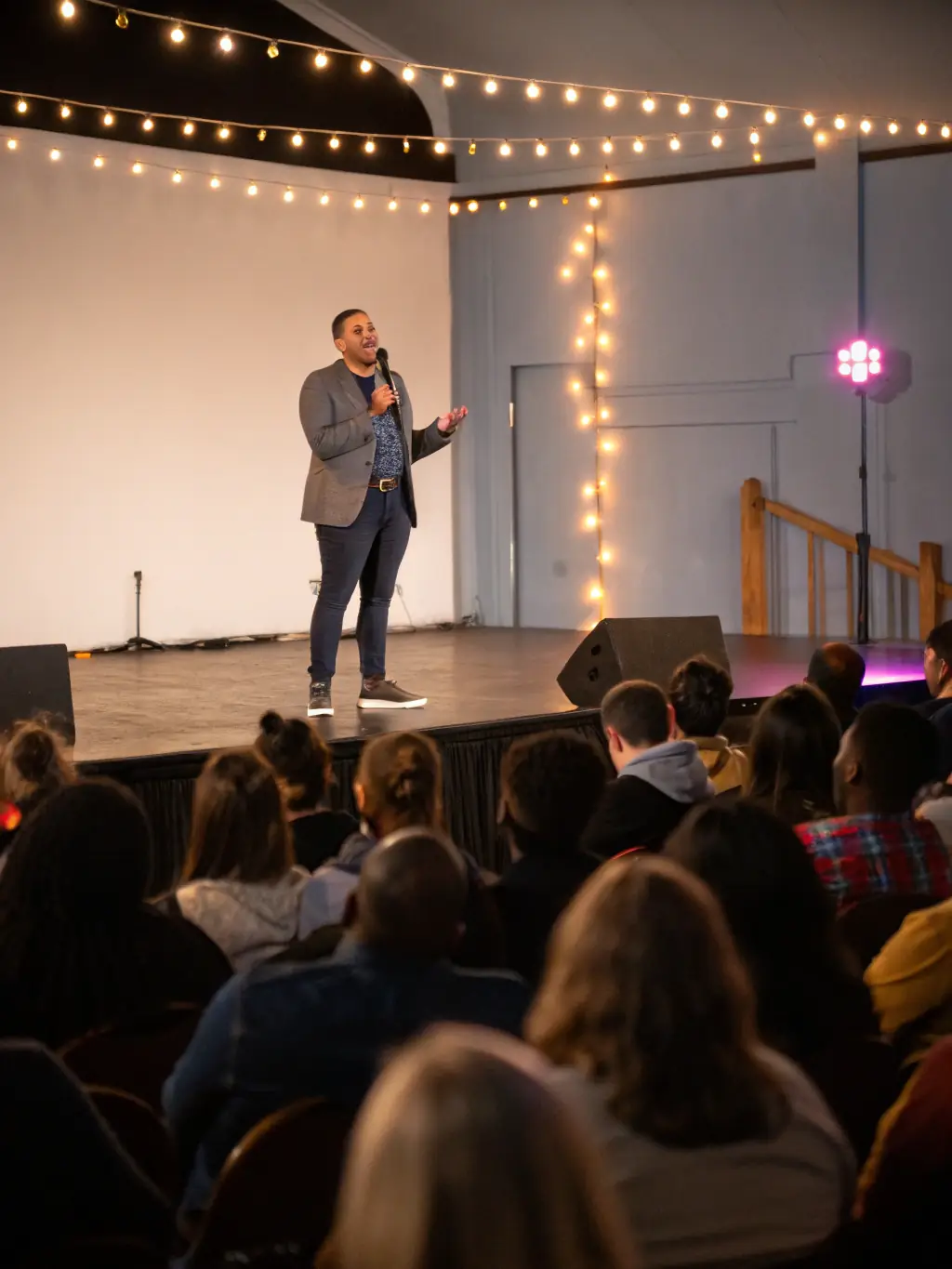 A professional presenter confidently delivering a keynote speech on a brightly lit stage, using a high-resolution projector to display engaging visuals, showcasing the impact of Top-Notch Event Tech's equipment on audience engagement.